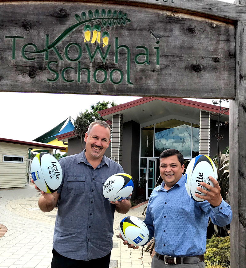 Tony Grey, Te Kowhai School Principal, receives the rugby balls from Nivitesh Kumar, CrestClean’s Waikato Regional Manager.
