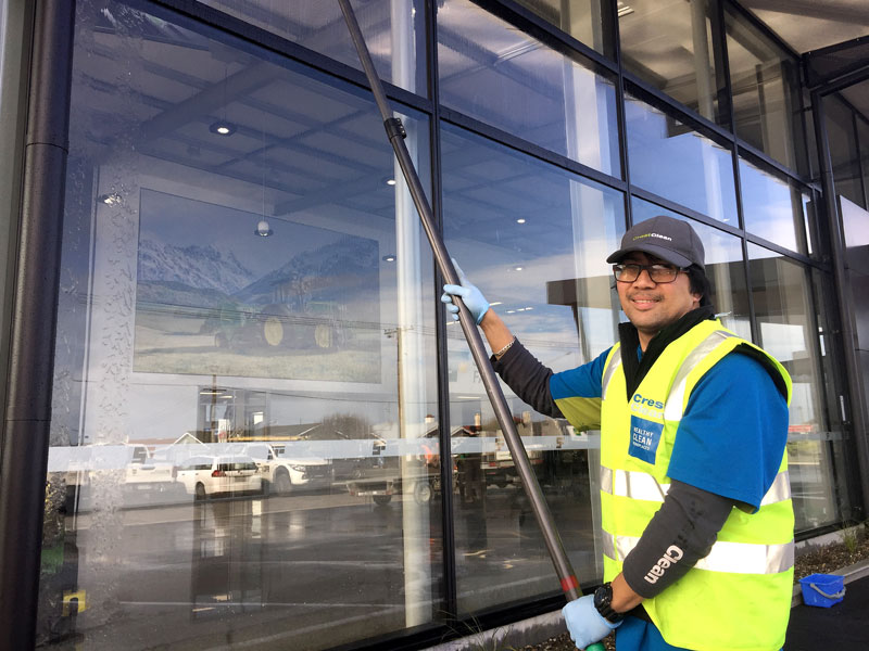 CrestClean franchisee Martin DeGuzman at work on the exterior of the Southland Farm Machinery building. 